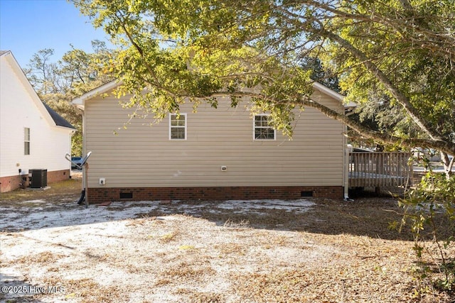 view of side of property featuring crawl space, cooling unit, and a wooden deck