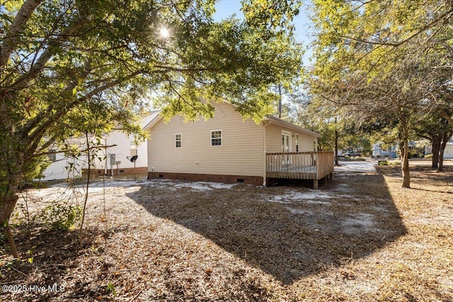 rear view of house featuring crawl space and a wooden deck