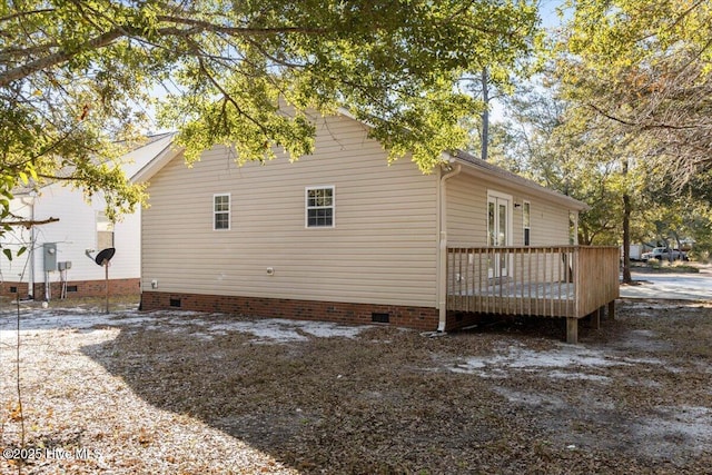 view of side of home with a deck and crawl space