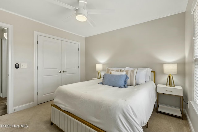 bedroom with baseboards, ornamental molding, a closet, and light colored carpet