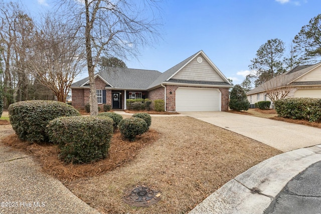 view of front facade with driveway, a shingled roof, a garage, and brick siding