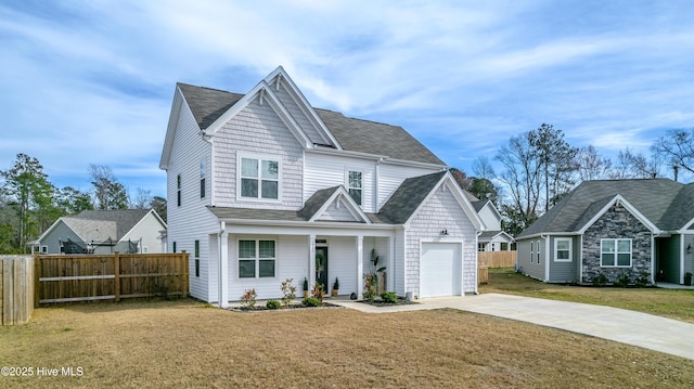 view of front of property featuring a front yard, covered porch, and a garage