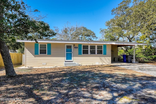 ranch-style house featuring driveway, fence, and a carport