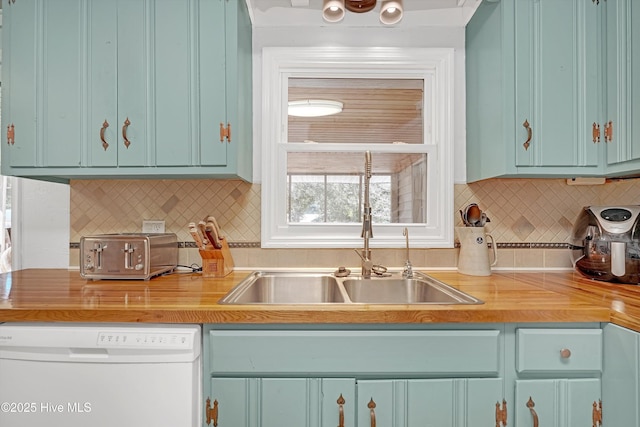 kitchen featuring a toaster, light countertops, backsplash, a sink, and dishwasher