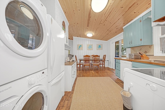 clothes washing area featuring crown molding, light wood finished floors, stacked washer / dryer, laundry area, and wooden ceiling