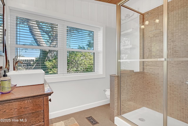 full bathroom featuring visible vents, baseboards, toilet, vanity, and a shower stall