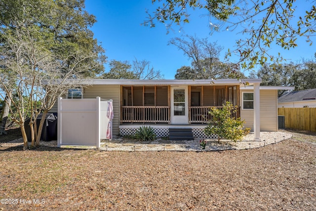 rear view of house with a porch and fence