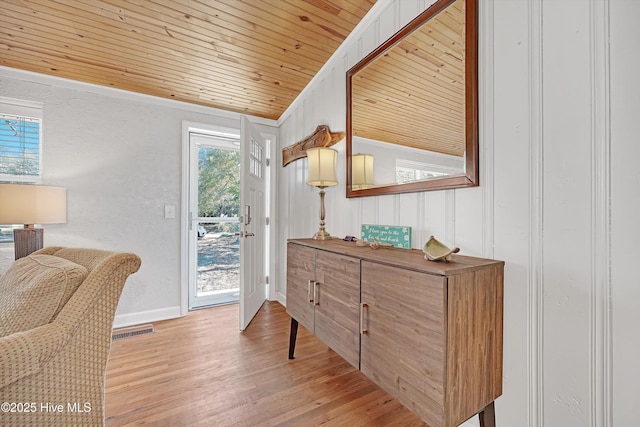 interior space with light wood finished floors, lofted ceiling, visible vents, wooden ceiling, and baseboards