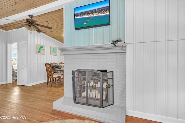 interior details with ceiling fan, wooden ceiling, a fireplace, wood finished floors, and baseboards