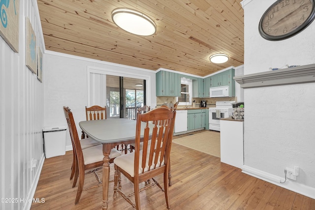 dining area with light wood-style floors, wood ceiling, ornamental molding, and vaulted ceiling