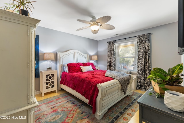 bedroom with visible vents, ceiling fan, and wood finished floors