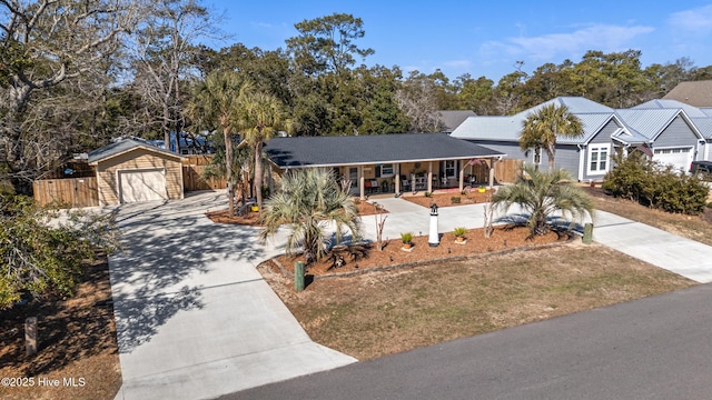 ranch-style home featuring a garage, a porch, driveway, and fence