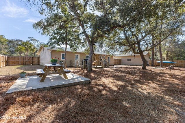 rear view of house featuring a fenced backyard and a patio