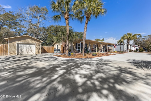 ranch-style home featuring a porch, driveway, a garage, and fence