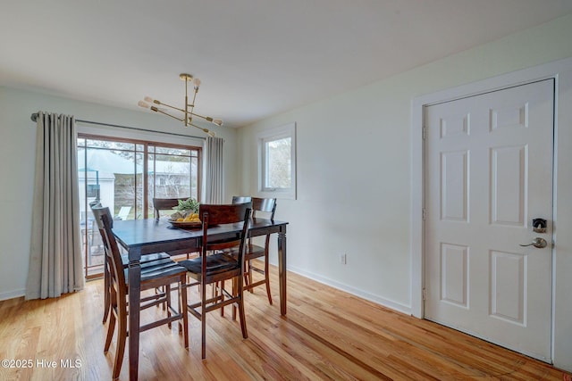 dining space featuring light wood-type flooring and baseboards