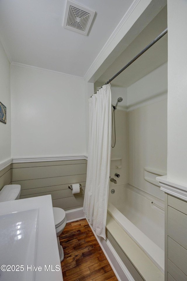 full bath with toilet, wainscoting, wood finished floors, and visible vents