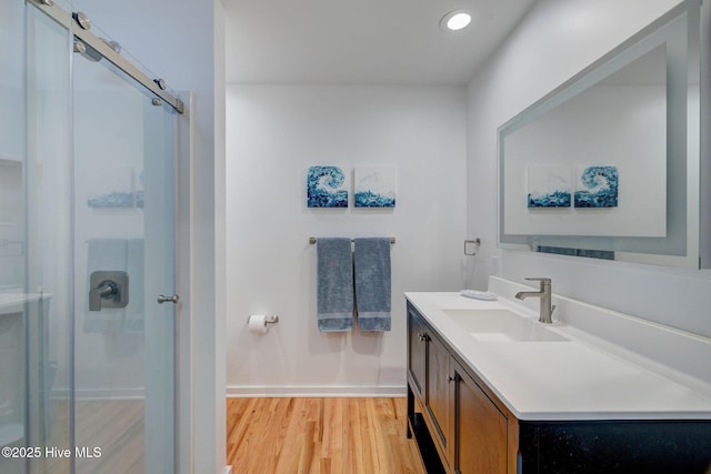 full bathroom featuring recessed lighting, a stall shower, vanity, wood finished floors, and baseboards