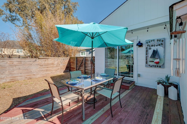 deck featuring outdoor dining space and fence