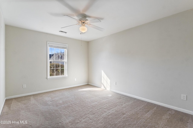 carpeted empty room with visible vents, ceiling fan, and baseboards