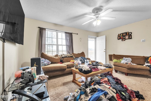 carpeted living room featuring a ceiling fan and a textured ceiling