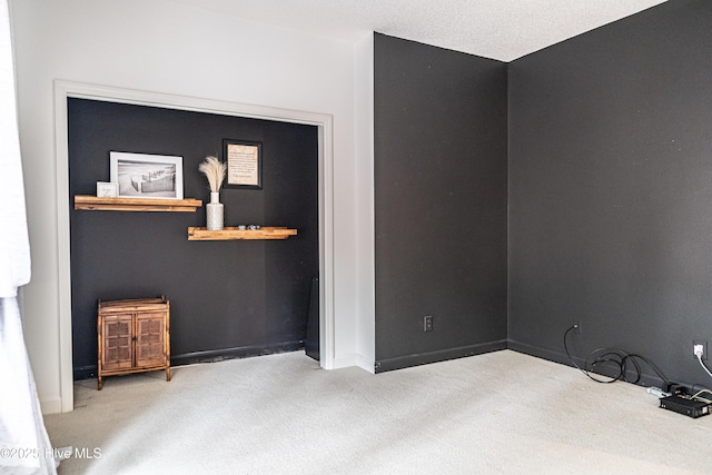 carpeted empty room featuring baseboards