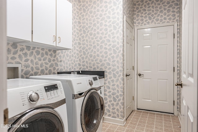 laundry area with cabinet space, wallpapered walls, washing machine and clothes dryer, and baseboards