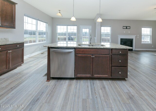 kitchen featuring dishwasher, open floor plan, a sink, and a wealth of natural light