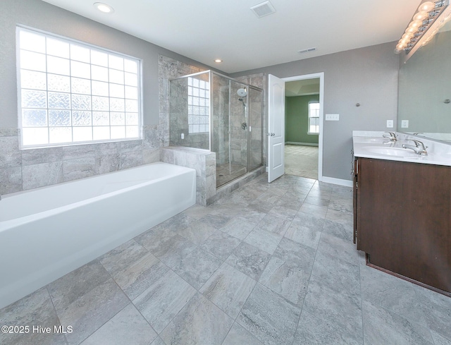 bathroom featuring plenty of natural light, a garden tub, visible vents, and a shower stall