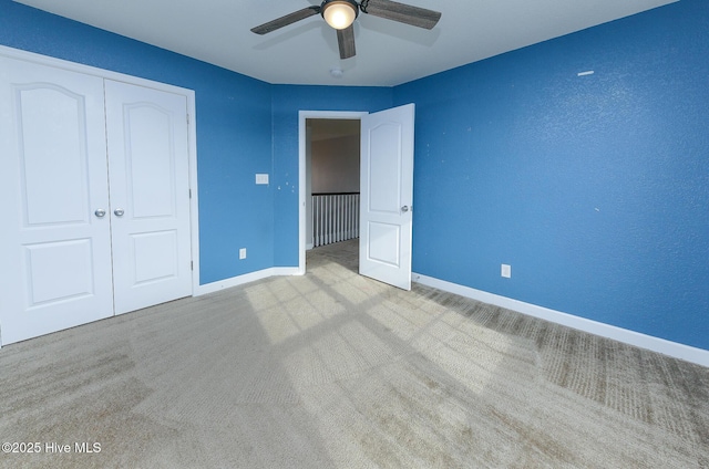 unfurnished bedroom featuring a ceiling fan, carpet, baseboards, and a closet