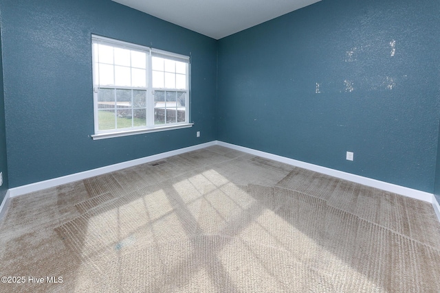 carpeted empty room featuring visible vents and baseboards