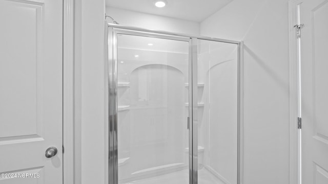 bathroom with a shower with door