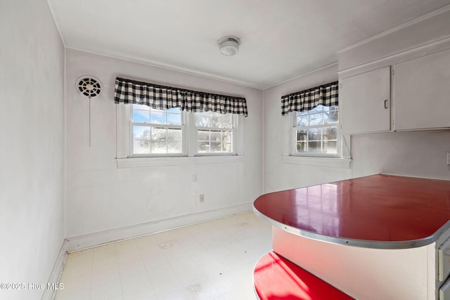 unfurnished dining area with light floors and baseboards