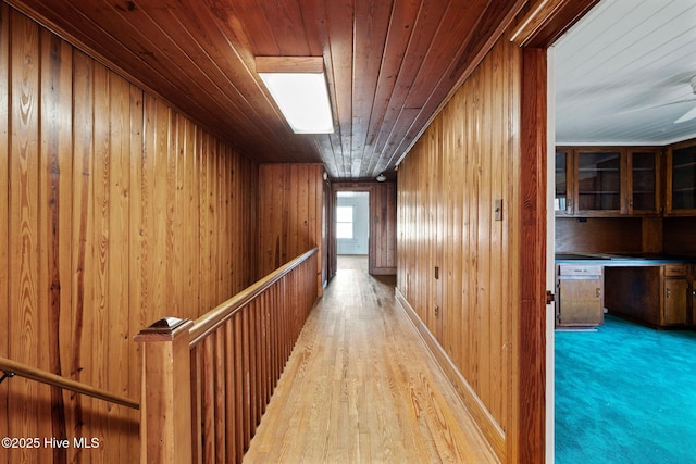 hall featuring wooden ceiling and wooden walls