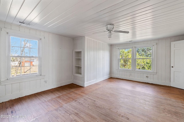 spare room featuring visible vents, ceiling fan, a wealth of natural light, and light wood-style flooring