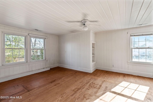 empty room with ceiling fan, visible vents, baseboards, baseboard heating, and light wood finished floors