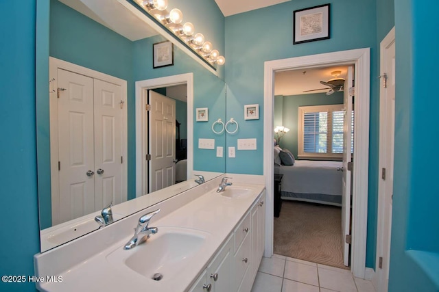 ensuite bathroom featuring double vanity, tile patterned flooring, and a sink