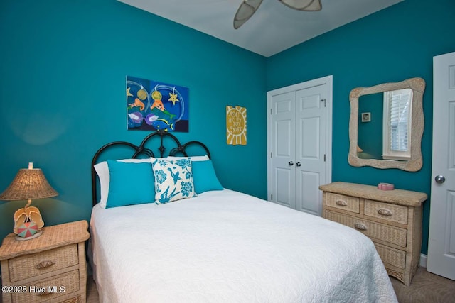 carpeted bedroom with ceiling fan and a closet