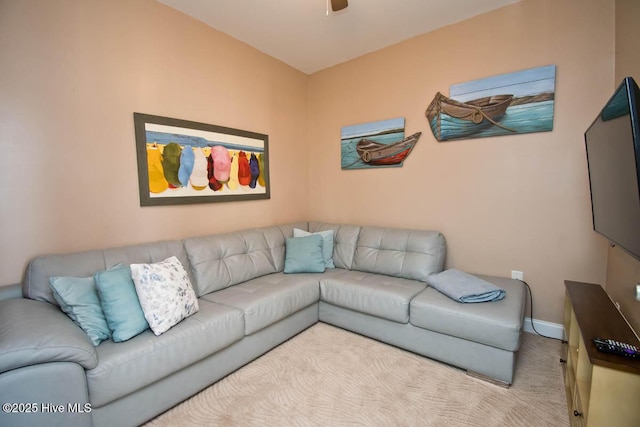 living room with baseboards, a ceiling fan, and light colored carpet