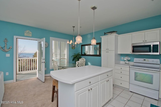 kitchen with white range with electric stovetop, a center island, stainless steel microwave, and white cabinetry