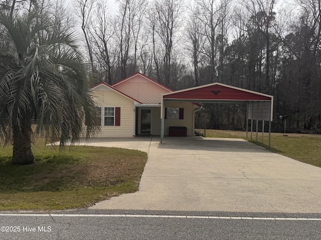 view of front of home featuring driveway, a front lawn, and a detached carport