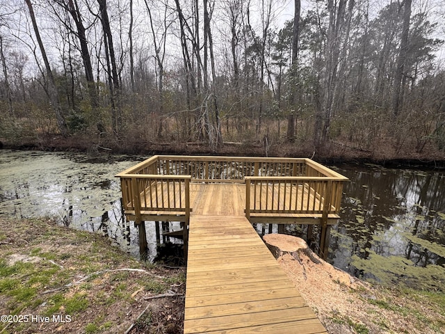 view of dock featuring a water view and a view of trees