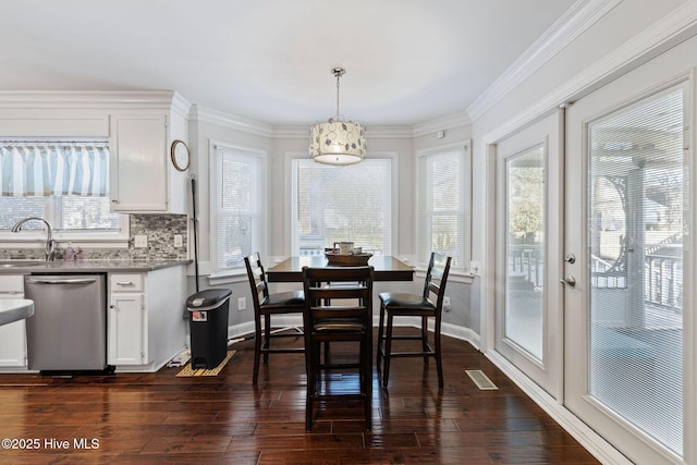 dining area with dark wood-style floors, visible vents, and baseboards