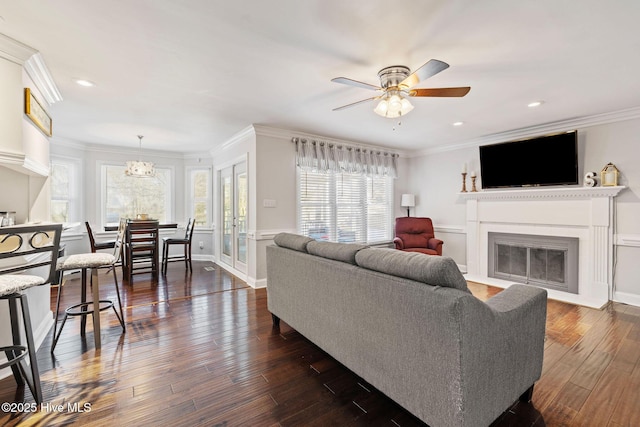 living area with a fireplace with flush hearth, ceiling fan, ornamental molding, dark wood-type flooring, and recessed lighting