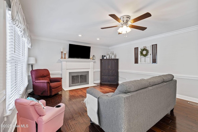 living room with crown molding, baseboards, dark wood finished floors, and a fireplace with flush hearth