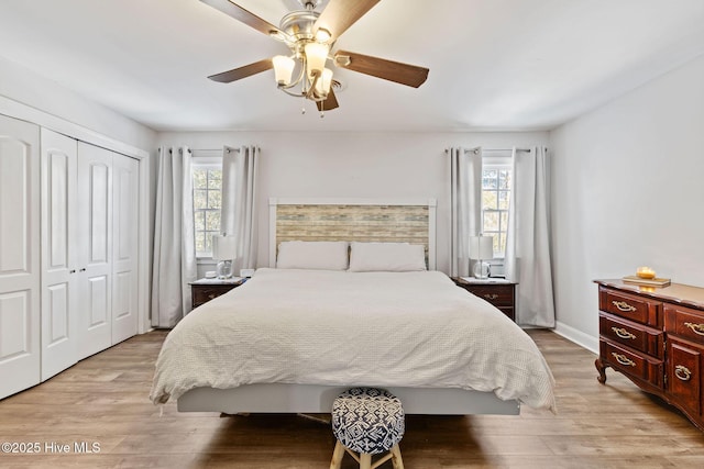 bedroom featuring multiple windows, light wood-type flooring, a closet, and a ceiling fan