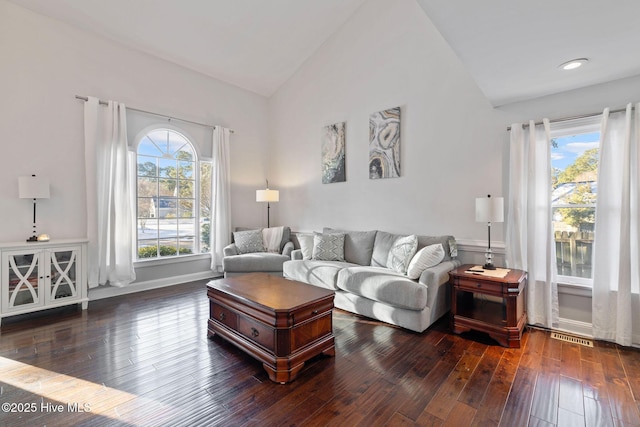 living room featuring high vaulted ceiling, dark wood-style flooring, a healthy amount of sunlight, and baseboards