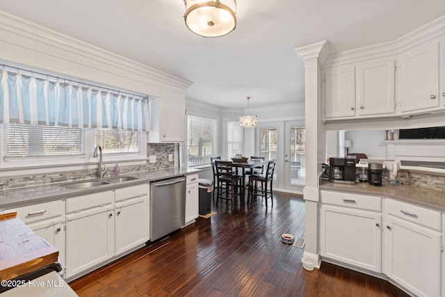 kitchen with ornamental molding, stainless steel dishwasher, white cabinetry, pendant lighting, and a sink