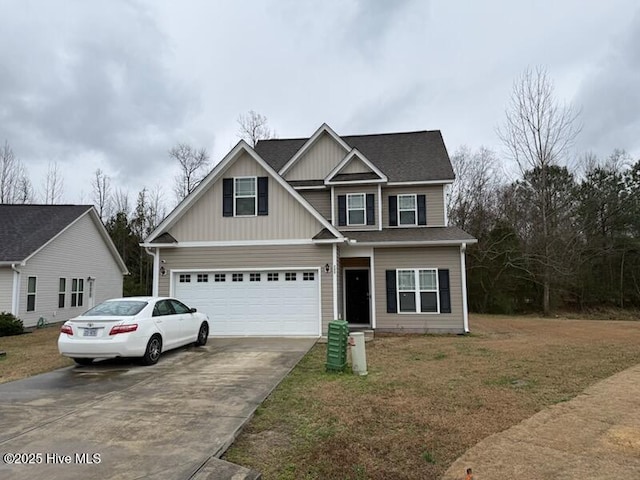 view of front of house featuring a garage, driveway, and a front lawn