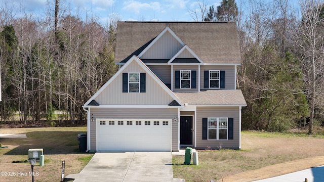 view of front of house featuring a front yard, driveway, roof with shingles, a garage, and board and batten siding