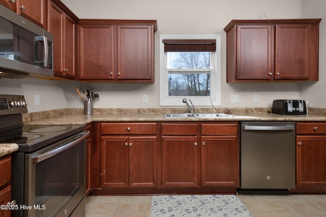 kitchen with a sink, appliances with stainless steel finishes, and light countertops